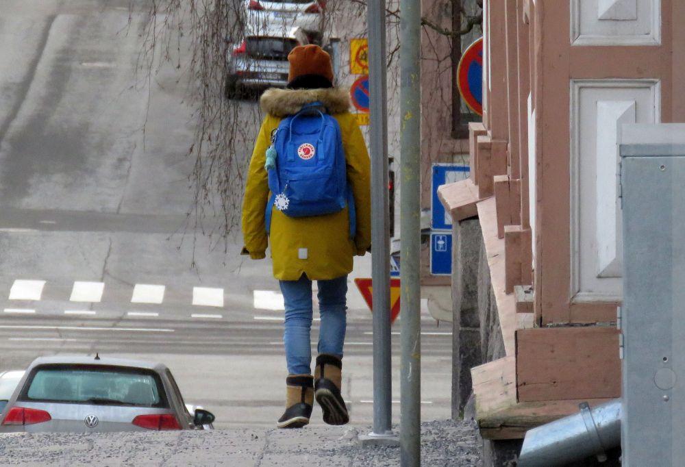 barn som går i stad med ryggsäck på ryggen