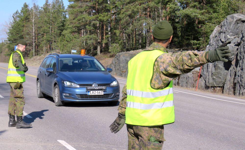 Två soldater dirigerar trafik på landsväg