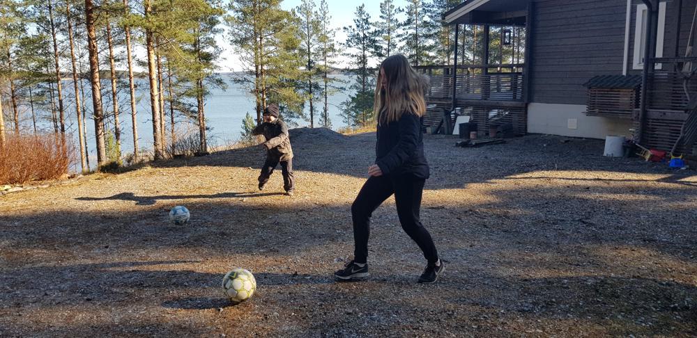 två barn sparkar två fotbollar