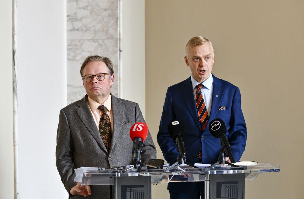 Två män med mikrofoner på bordet.