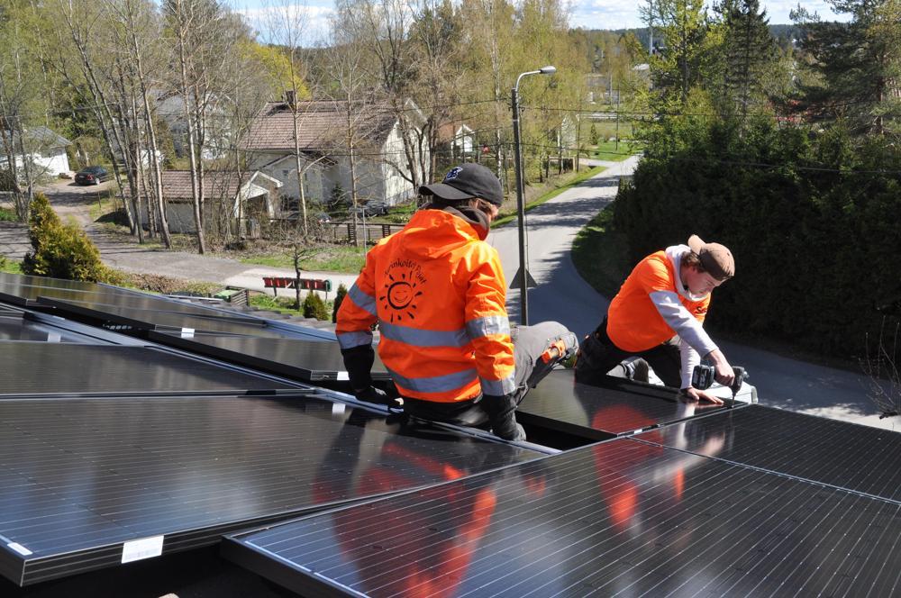 yrkesmän installerar solpaneler på hustak