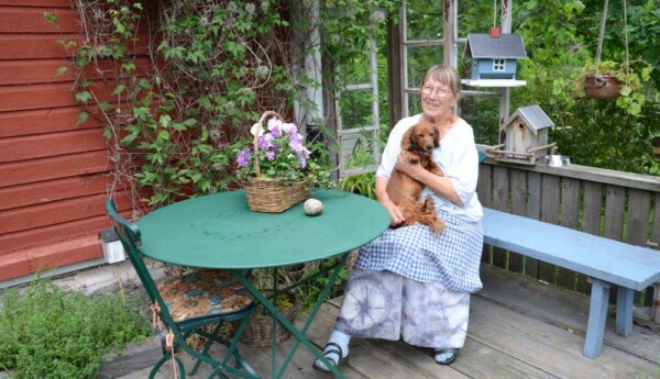 En kvinna sitter utomhus med hund.