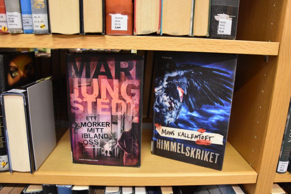 Två deckarromaner på en bibliotekshylla.