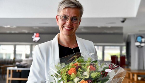 Porträtt av kvinna som håller en färggrann blombukett