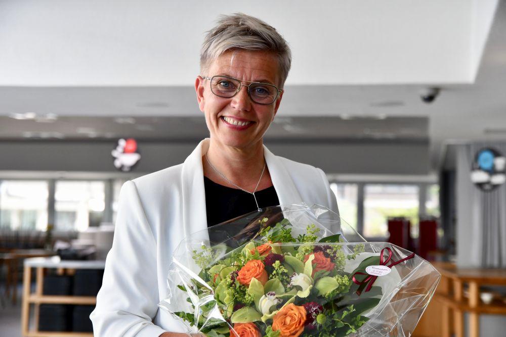 Porträtt av kvinna som håller en färggrann blombukett
