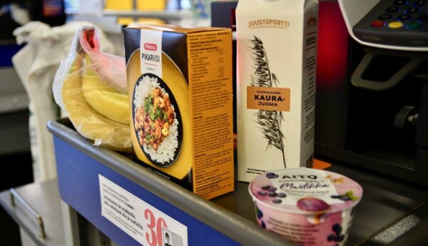 Matvaror som bananer, ris, havremjölk och kvarg på ett rullband i en matbutik.
