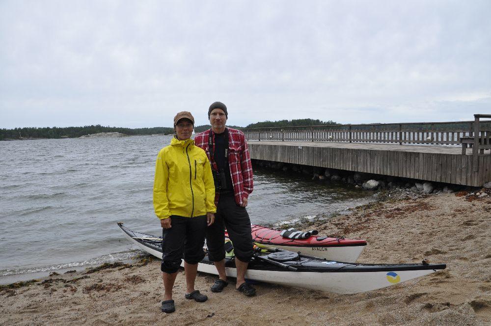 två personer och två kajaker på en strand