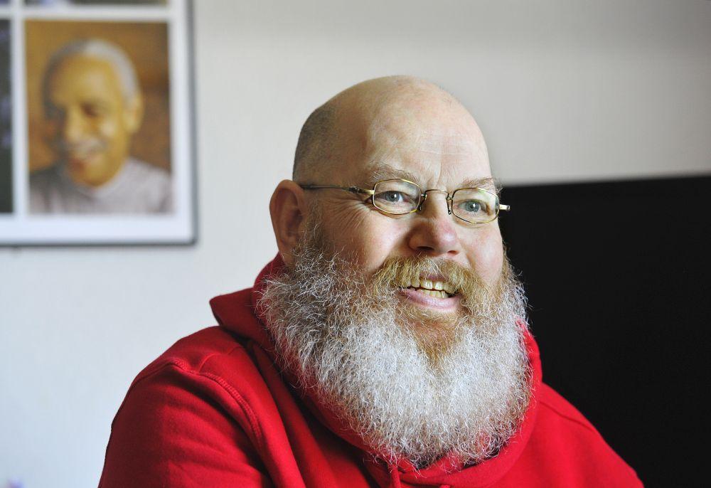 Porträtt av en skäggig man inomhus.