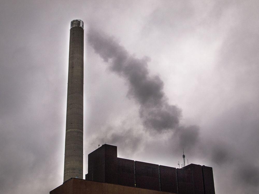 rykande industriskorsten mot molnig himmel