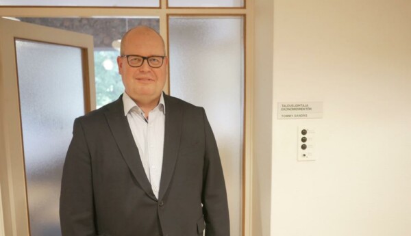 Skallig herre vid dörr till kontor.