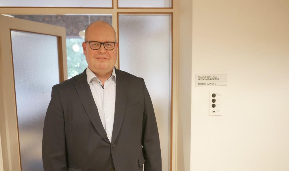 Skallig herre vid dörr till kontor.