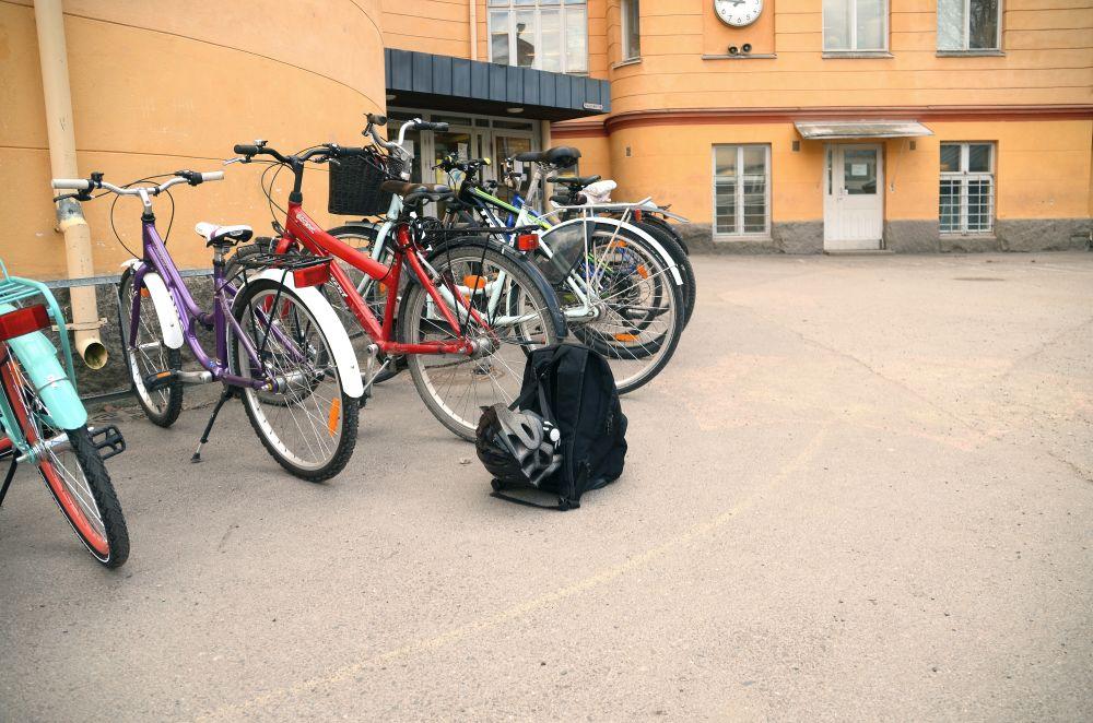 En ryggsäck och en hjälm bredvid cyklar.
