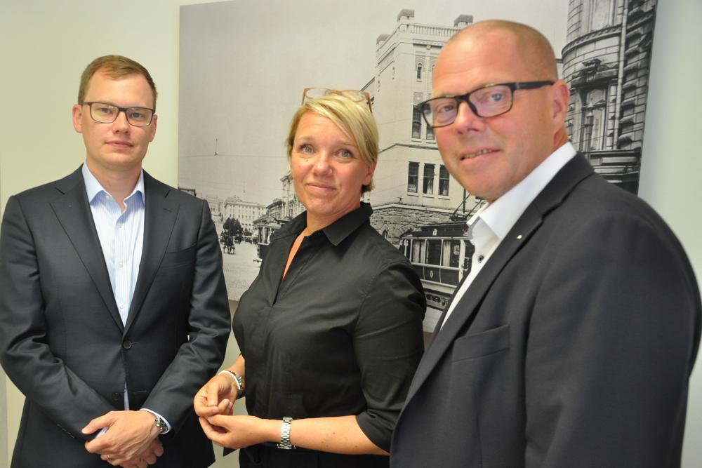 tre bankdirektörer i Aktia bank, en kvinna och två män, poserar framför kameran