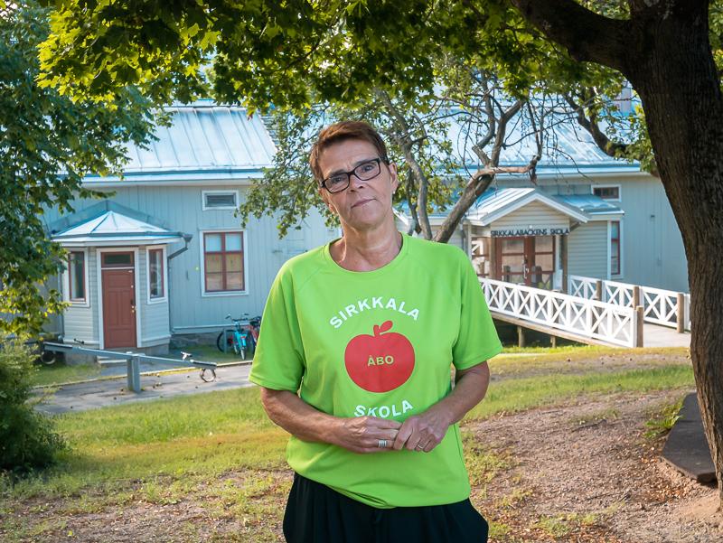 Dam i grön skjorta på skolgård