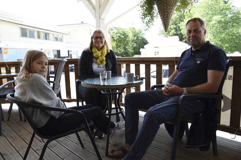 En familj sitter vid ett cafébord.