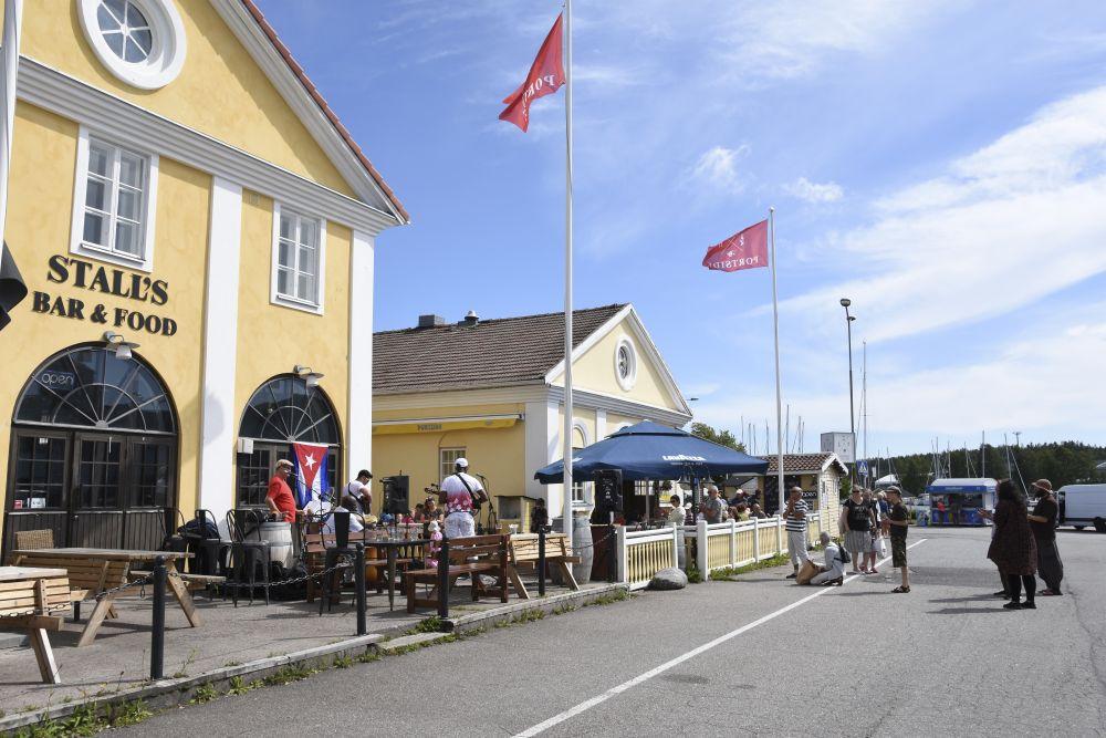 Två gamla gula stenhus med uteserveringar.
