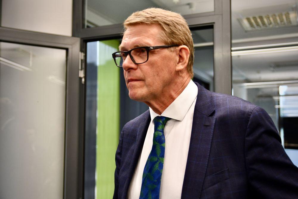 Kostymklädd man som verkar vara omedveten om att han blir fotograferad och är på väg förbli fotografen.. 