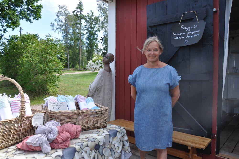 En kvinna står vid en försälningsbod