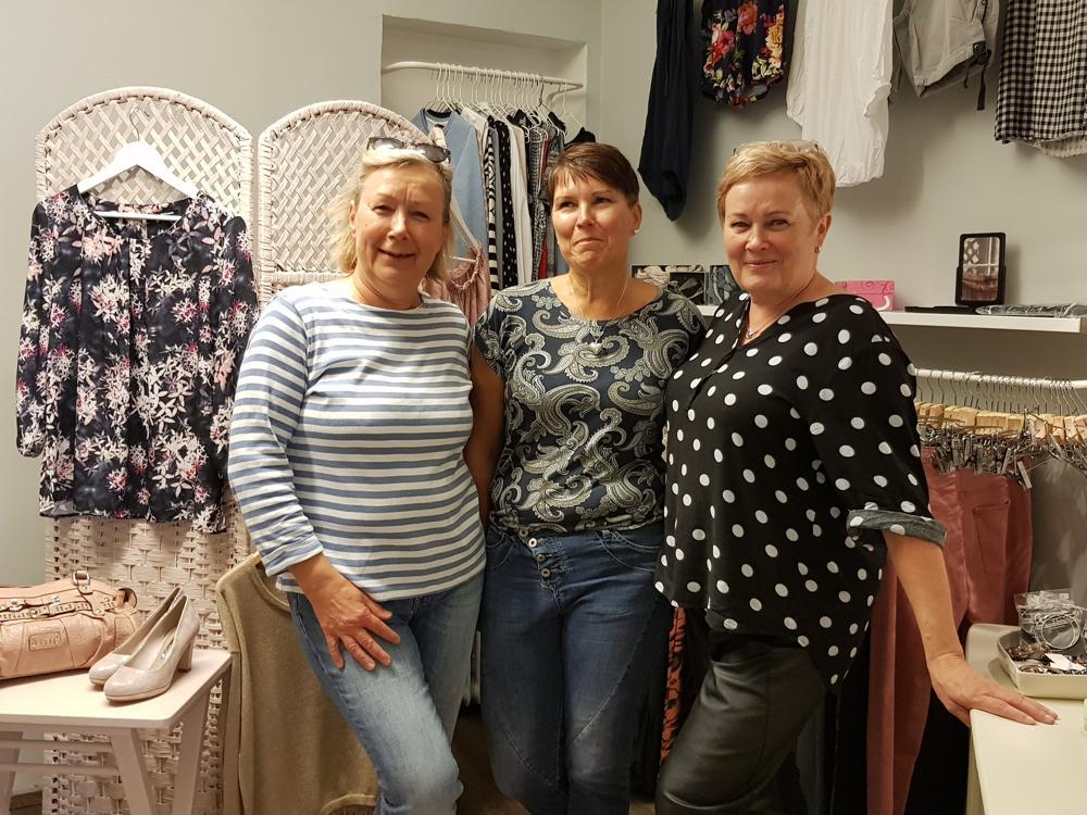 tre kvinnor i en klädaffär med second hand-kläder