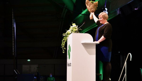 Kvinna med blombukett i en talarstol.
