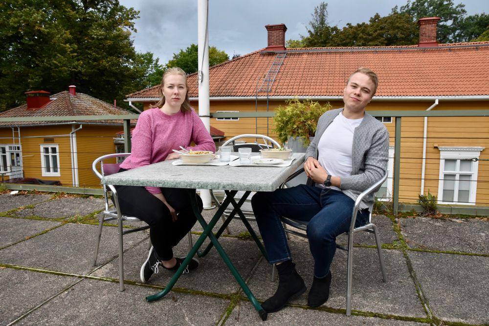 Två unga personer vid ett bord utomhus.