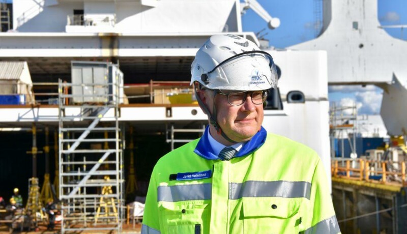 En man i hjälm och arbetsjacka på ett varv.