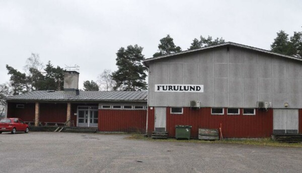 Stort föreningshus i grått ocg vitt, med skylten "Furulund"