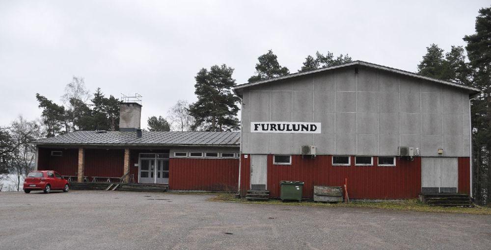 Stort föreningshus i grått ocg vitt, med skylten "Furulund"