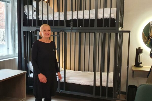 kvinna står framför en säng som har högt galler