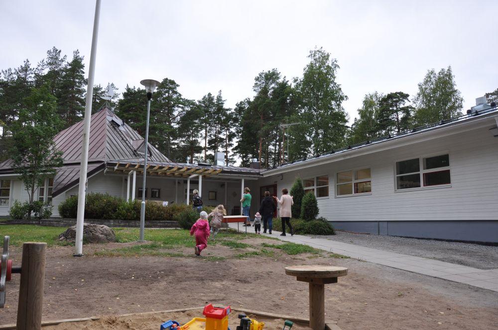 barn och vuxna som springer in från en gård, Daghemmet Karusellen i nagu