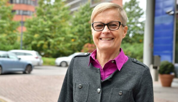 blond dam med kort hår står vid väg