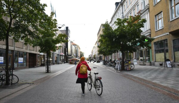 människa leder cykel på rätt tom o öde gata