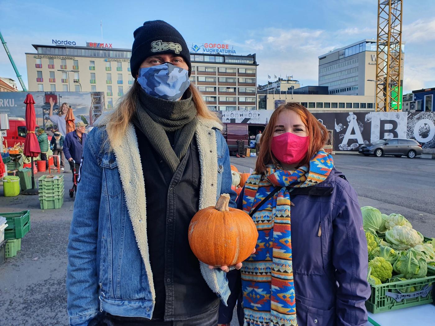 Två personer med en pumpa på ett torg.