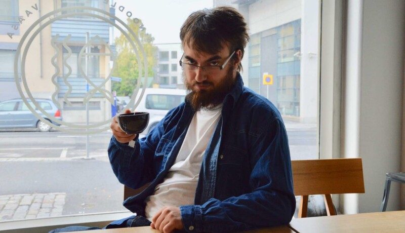 Un man dricker kaffe el te ur mugg