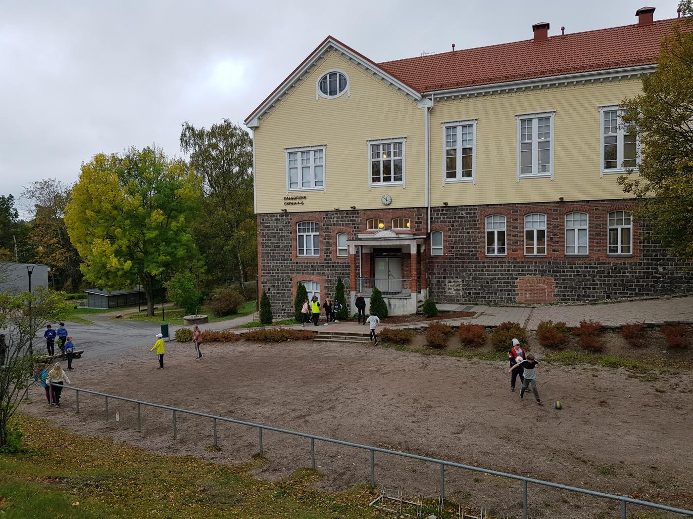 skolhus. Elever syns på gården.