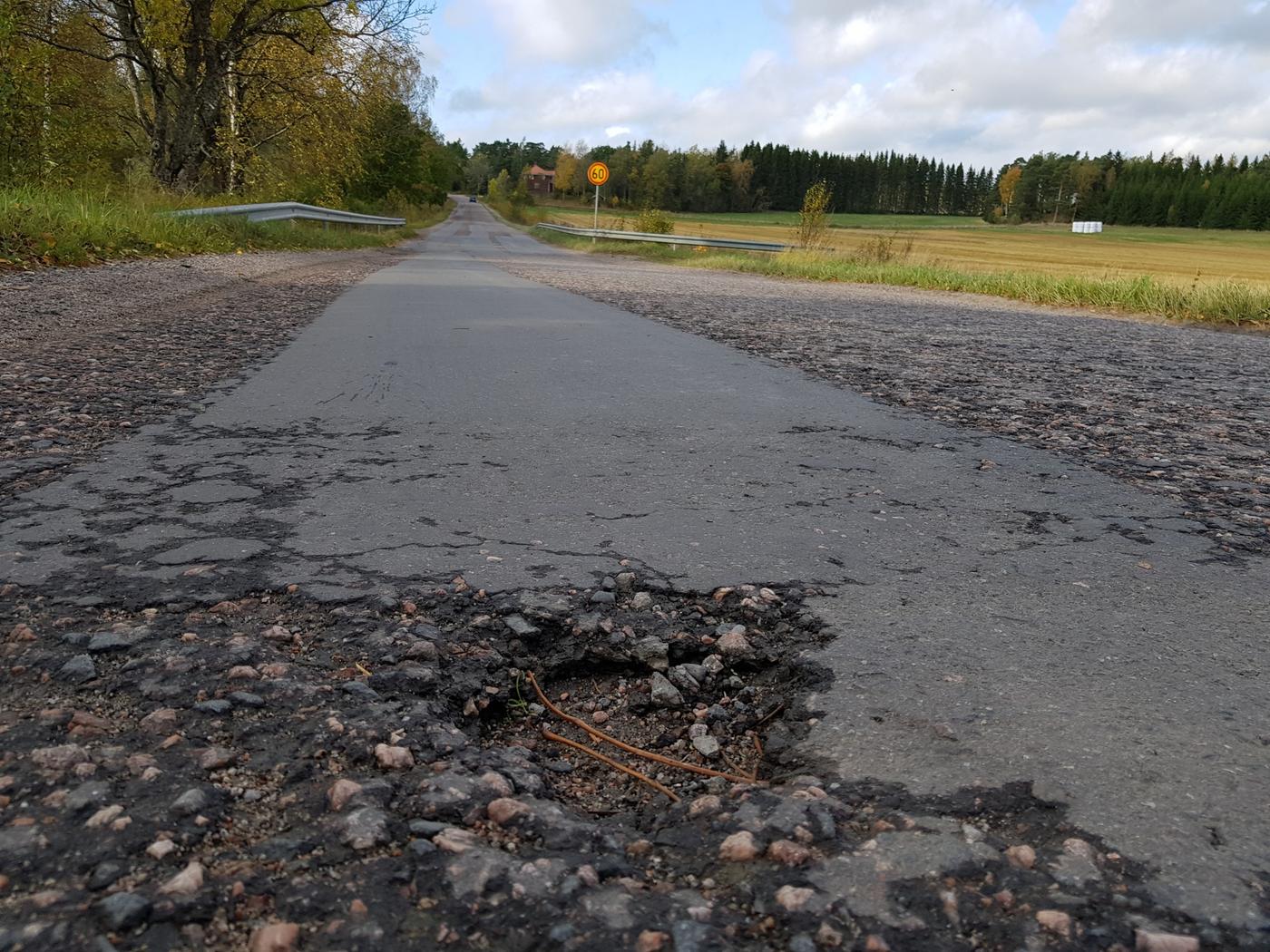 Asfaltväg med ett hål i.