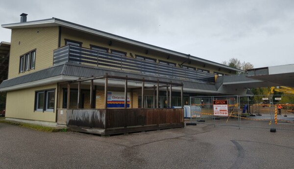 Mindre tvåvåningsbyggnad. Stängsel ingärdar gården, där rivningsarbeten pågår.