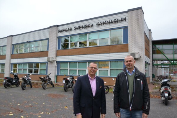 två män utanför en skolbyggnad