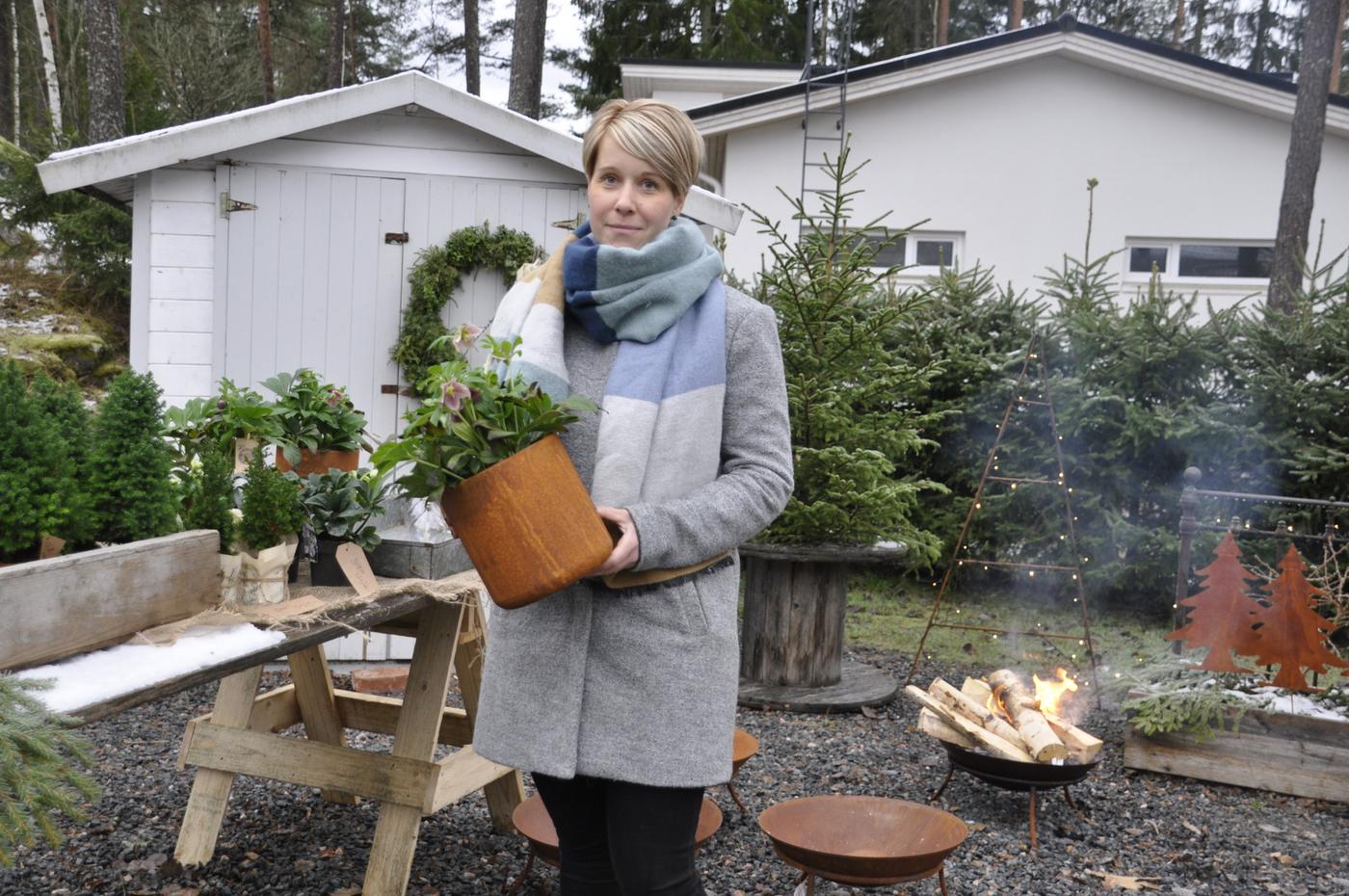 Dam utomhus med en kruka i famnen