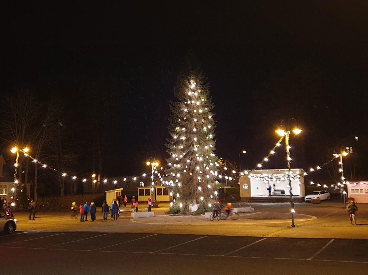 Julgran med lampor på ett torg