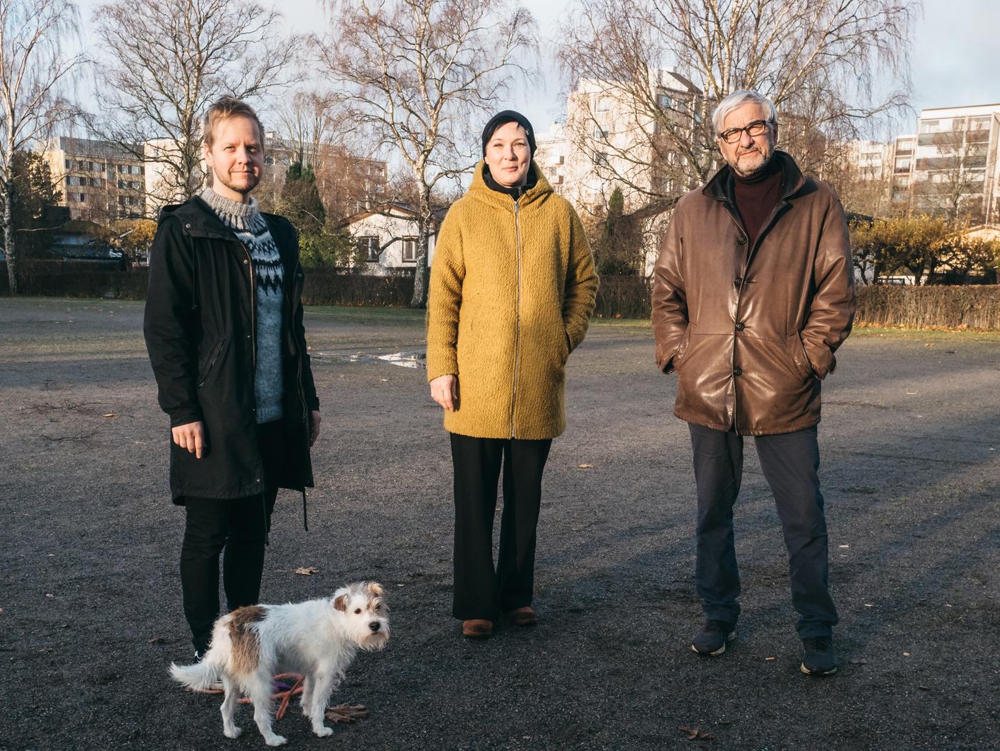 tre personer står på rad i morgonsol i park i bostadsområde