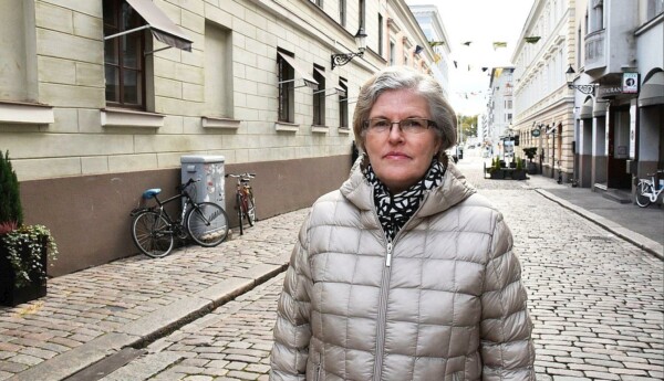 Katri Viinikka i grå jacka på en kullerstensgata i Helsingfors.