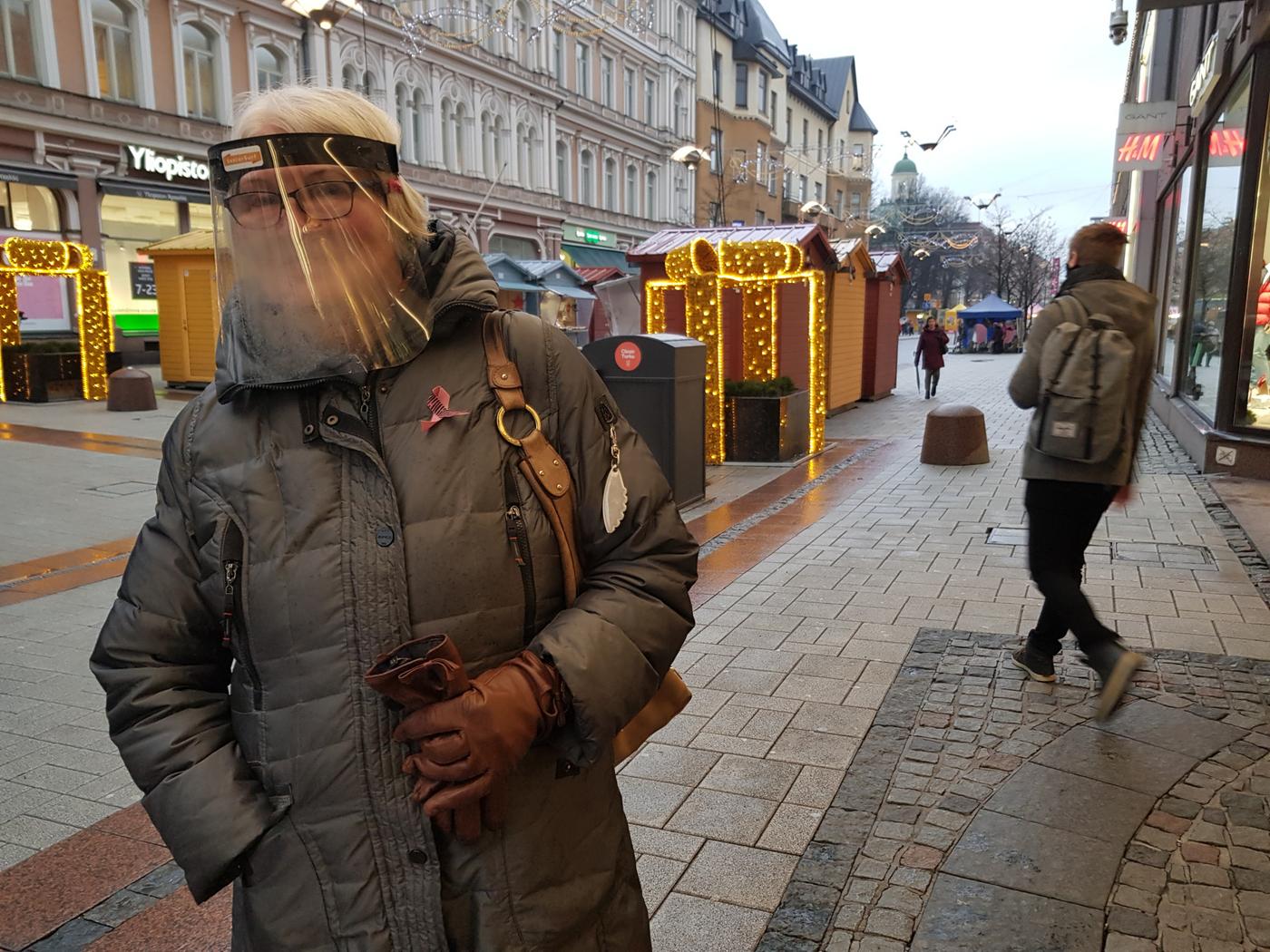 kvinna i grå jacka med ansiktsvisir