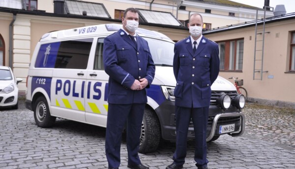 två poliser framför en bil