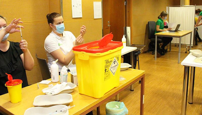 personer vid bord förbereder vacciner