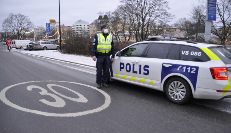 En polis står utanför en polisbil