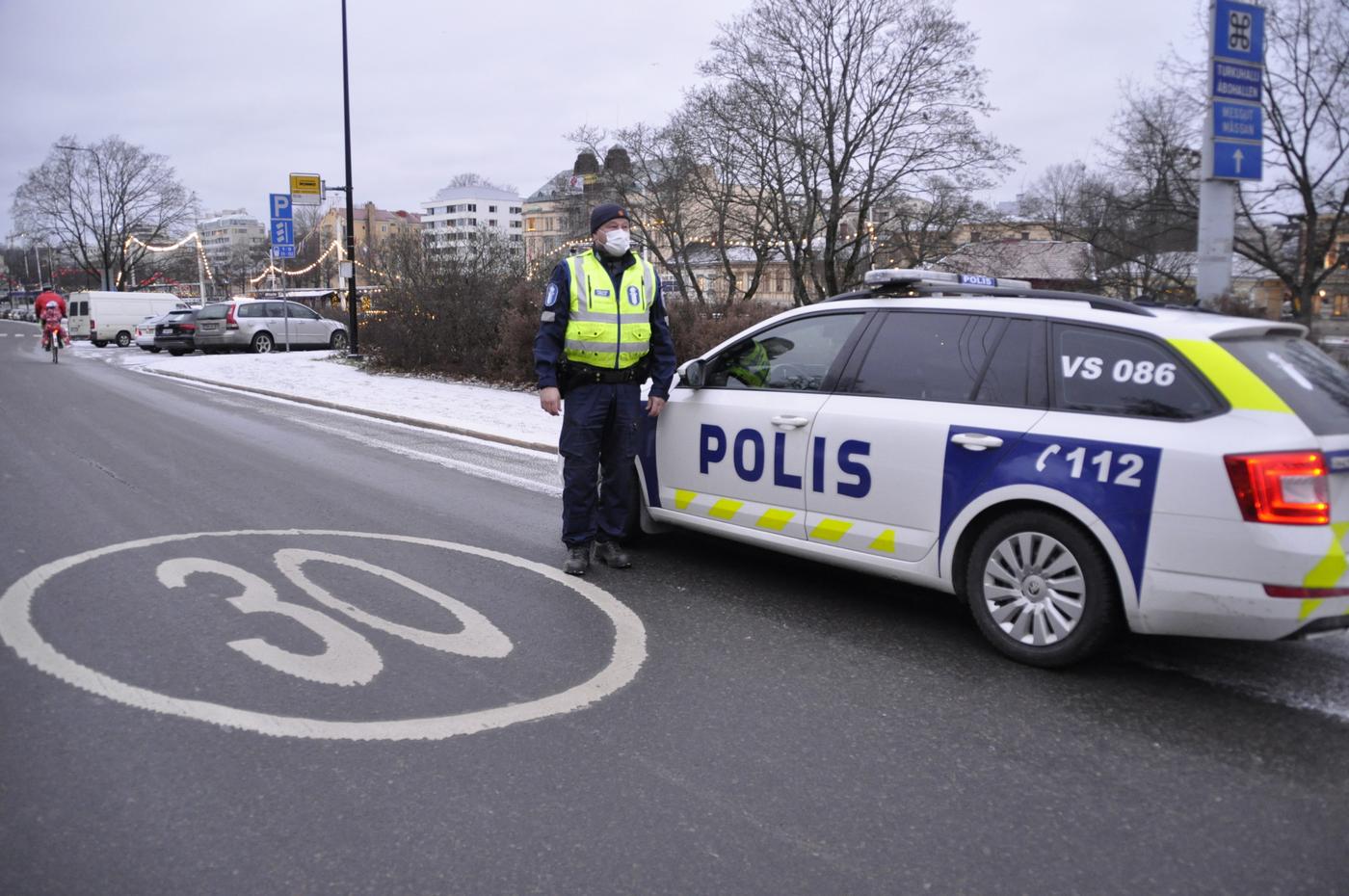 En polis står utanför en polisbil