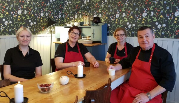 Restaurangkökspersonal har kaffepaus i rum med mörk tapet med blommor