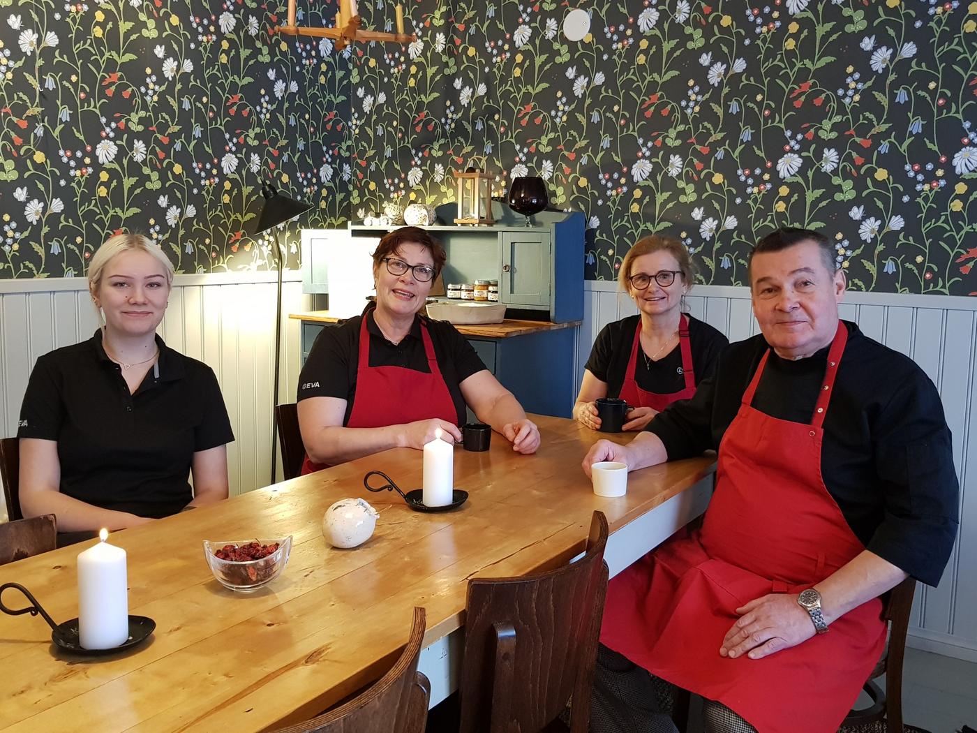 Restaurangkökspersonal har kaffepaus i rum med mörk tapet med blommor