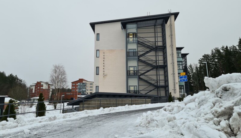 en hög byggnad vid slutet av en snöig väg